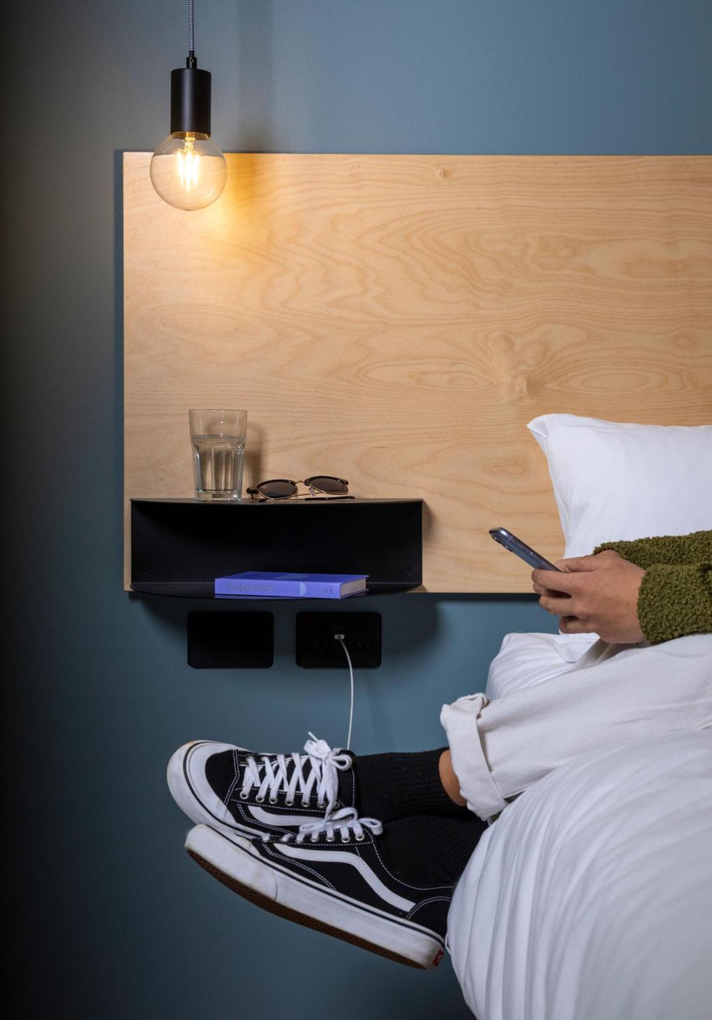 Lylo Auckland Hotel 객실 사진 A phone being used in bed
